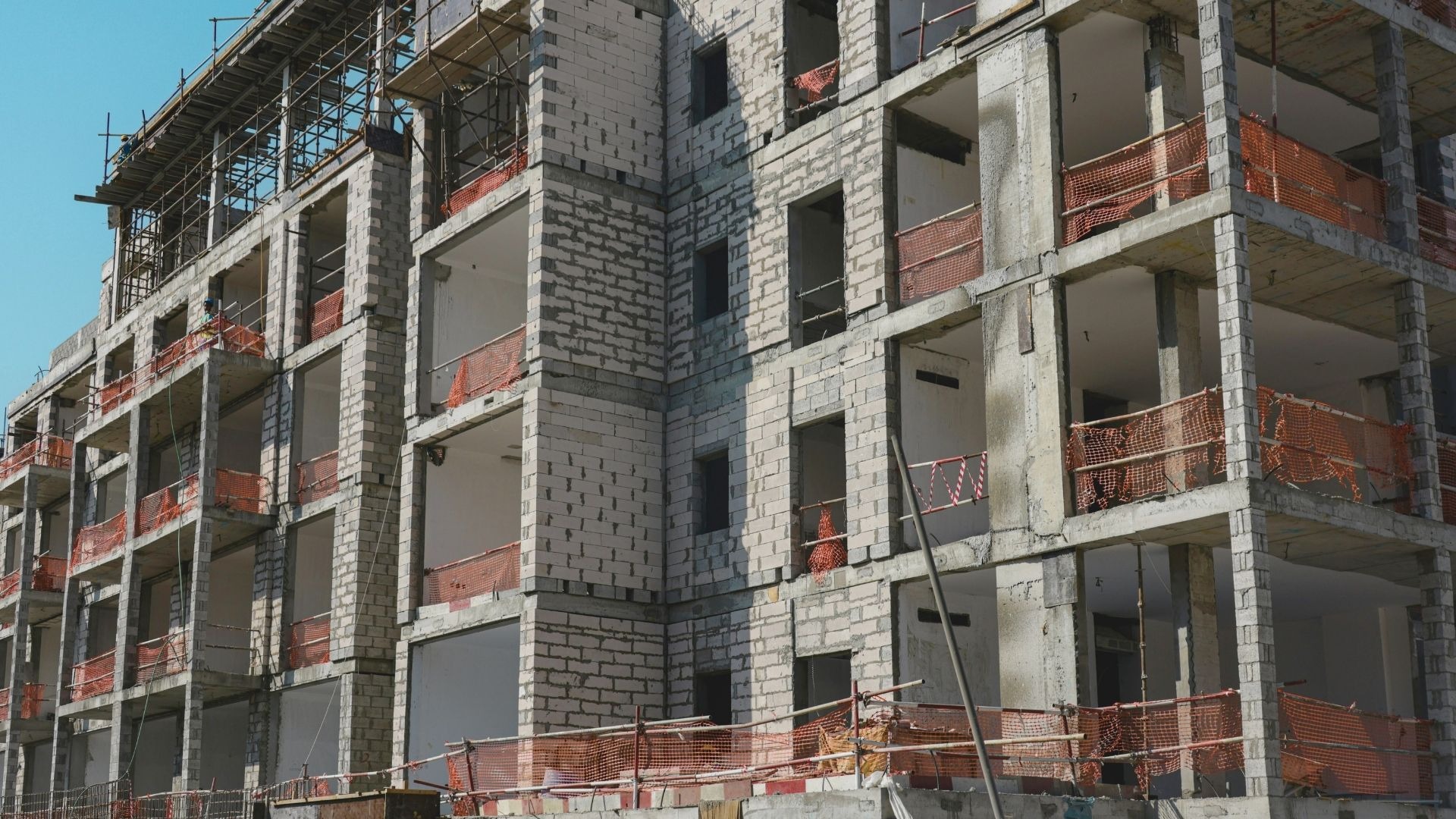 Building construction with scaffolding and orange safety nets